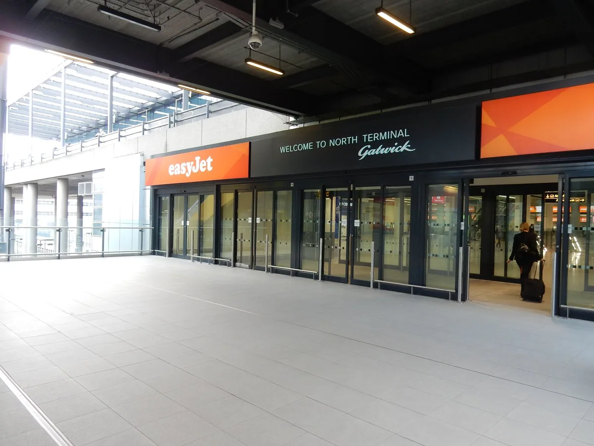 Glass entrance doors to Gatwick's North Terminal under a Welcome to North Terminal sign