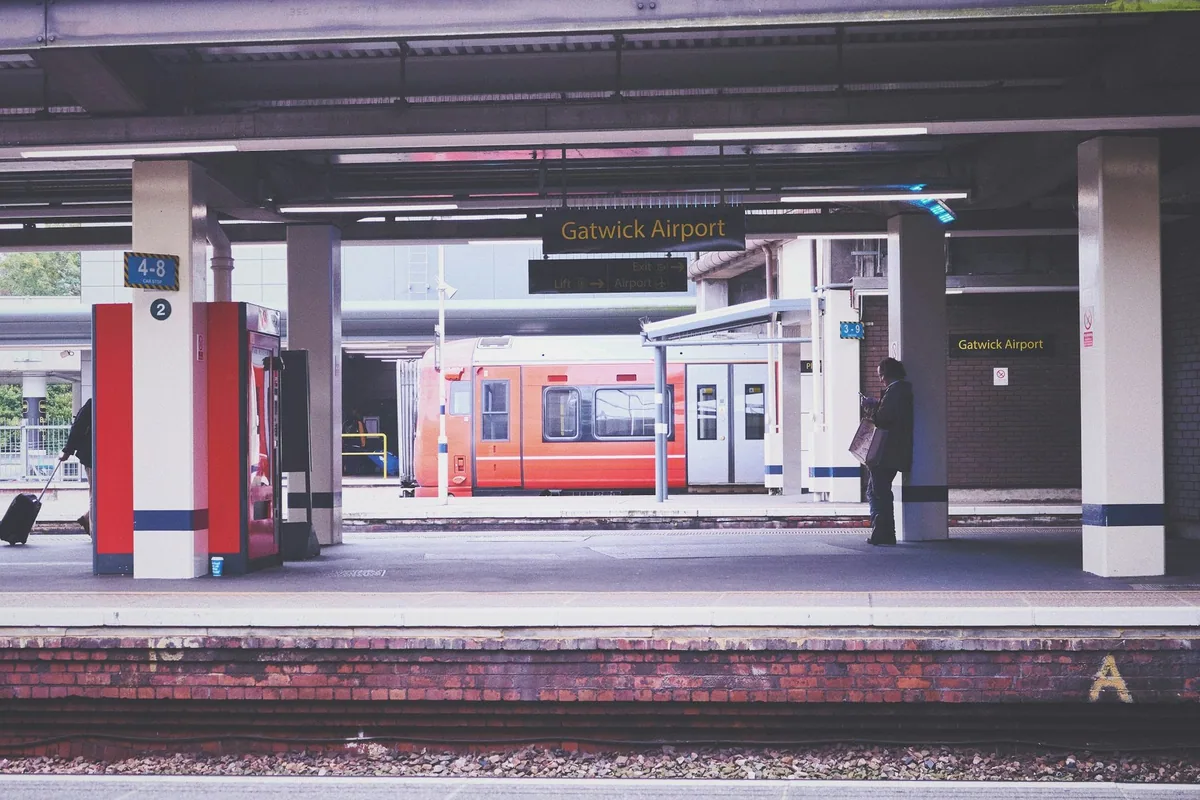 A train waiting at the platform under the Gatwick Airport station sign