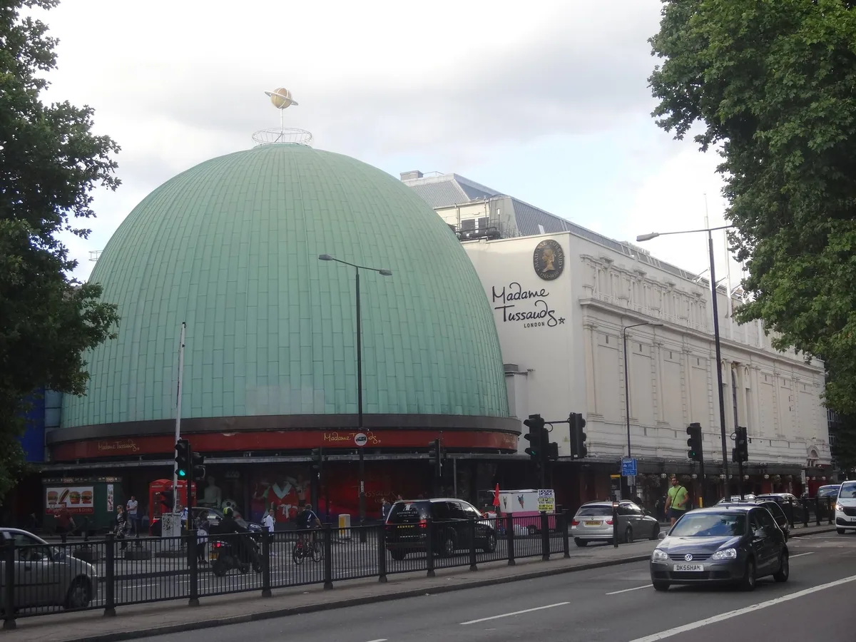 The green dome and white frontage of Madame Tussauds on Marylebone Road, with traffic passing outside