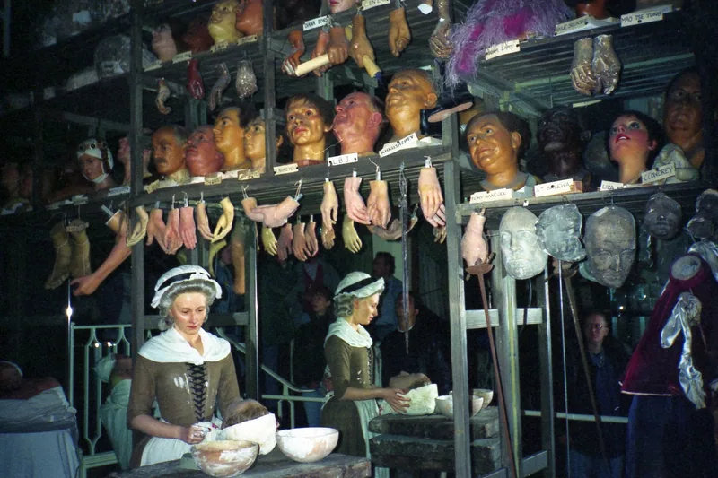 Wax tableau of Marie Tussaud at work, with shelves of wax heads and hands behind her, at Madame Tussauds London