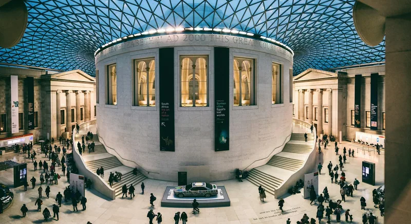 Visitors crossing the Queen Elizabeth II Great Court around the round Reading Room under the glass roof