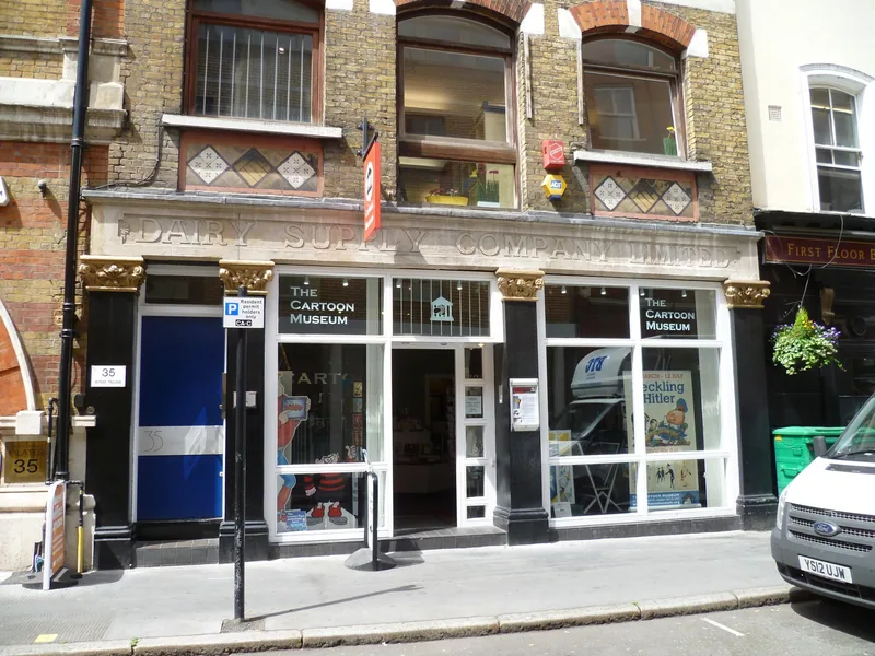 The Cartoon Museum shopfront with gold lettering on a narrow London street