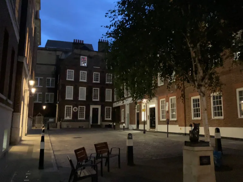 Gough Square at dusk under gas lamps, with the statue of Hodge the cat on its plinth
