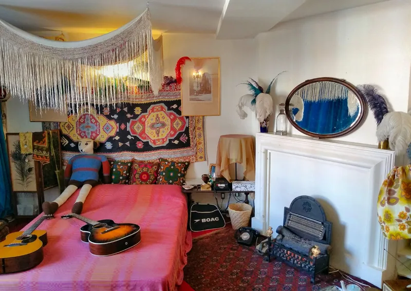 Jimi Hendrix's recreated bedroom with guitars on a pink bedspread, embroidered hangings and a round mirror