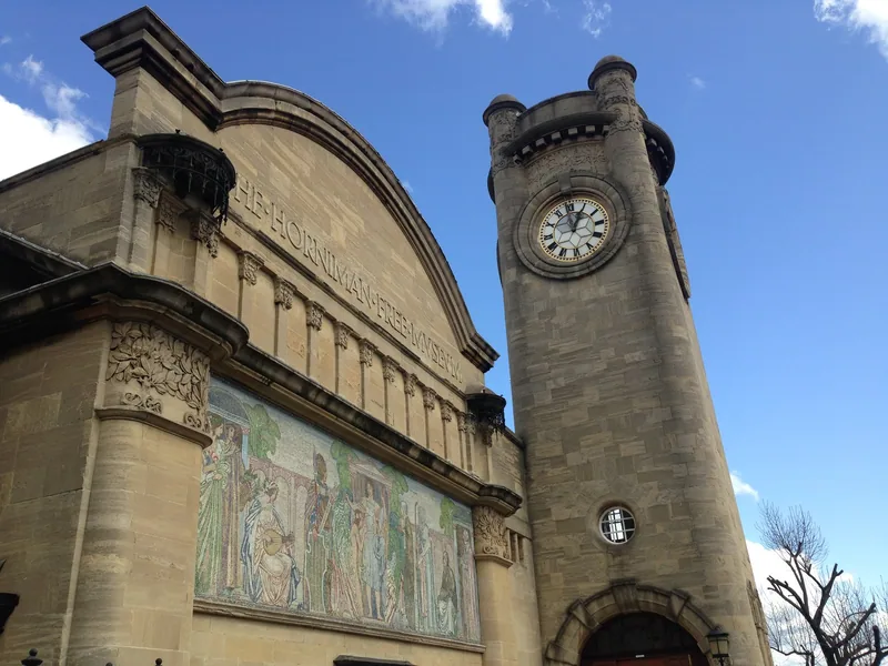 The Horniman Museum's stone facade with its mosaic frieze and clock tower against a blue sky