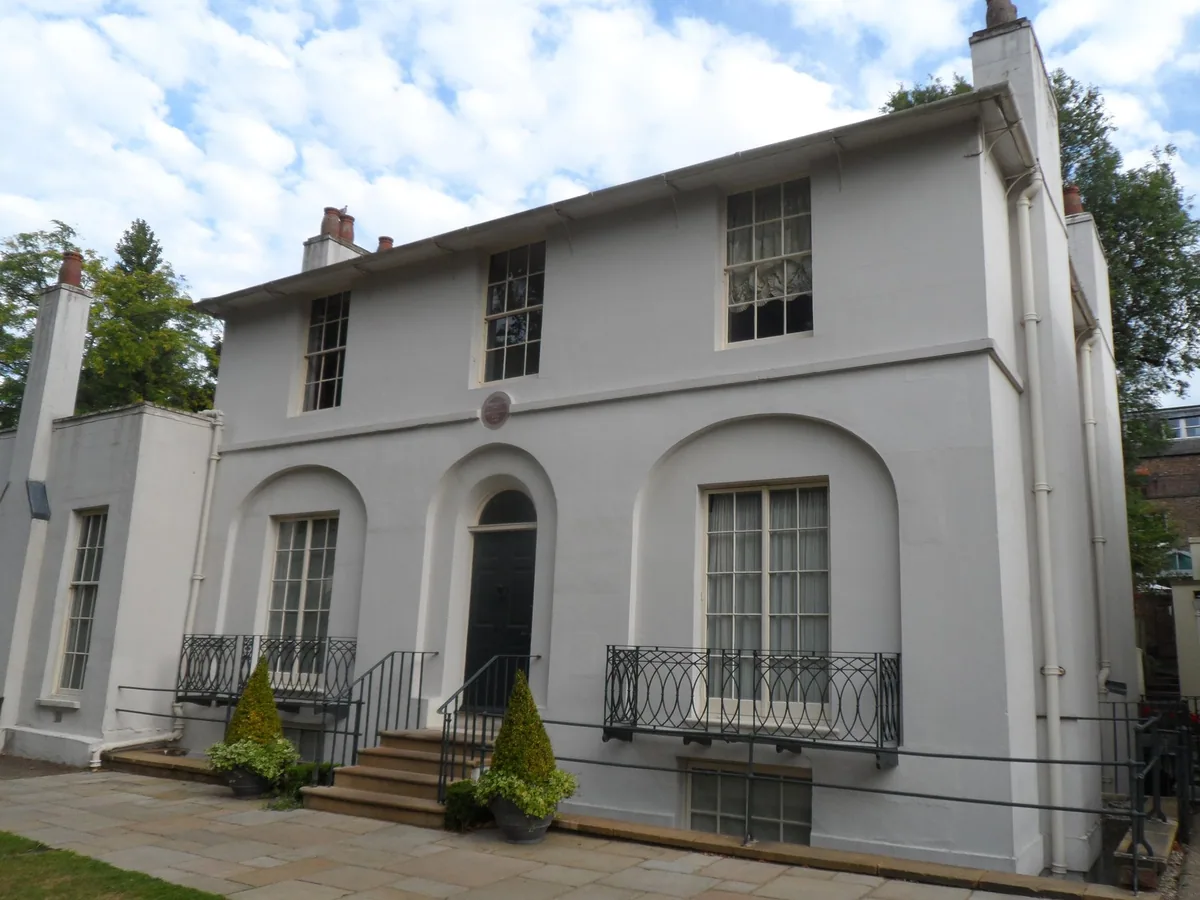 The white Regency villa of Keats House in Hampstead, seen from the front with its railed steps and porch