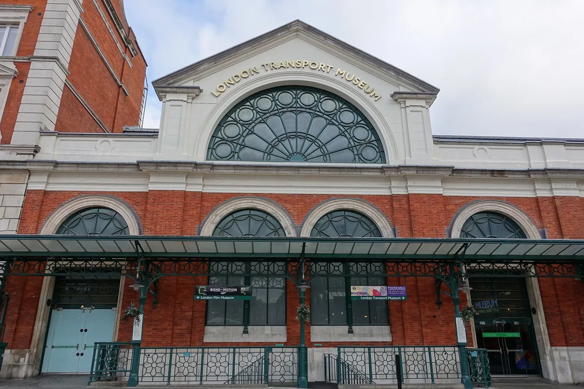 The red brick and glass frontage of the London Transport Museum in Covent Garden with its name above the arched window