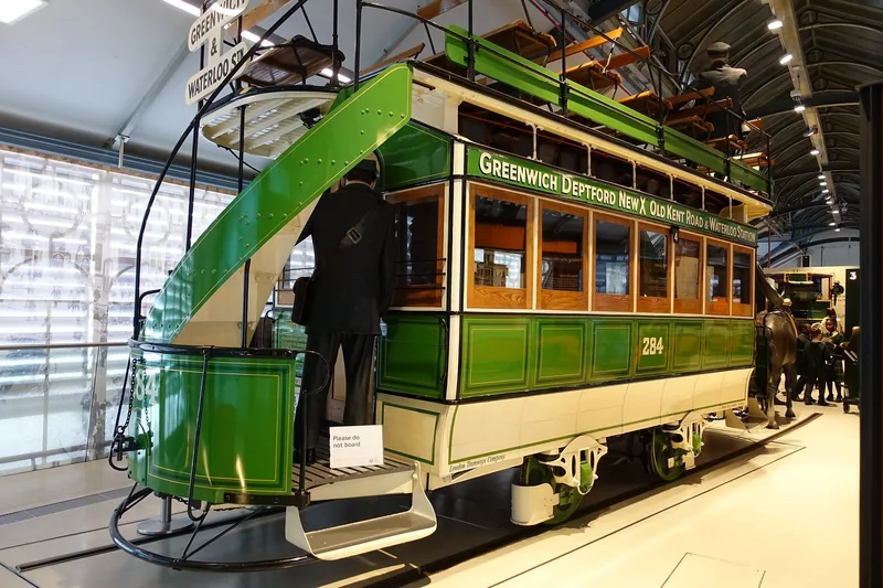 A restored green open-top tram on display inside the London Transport Museum