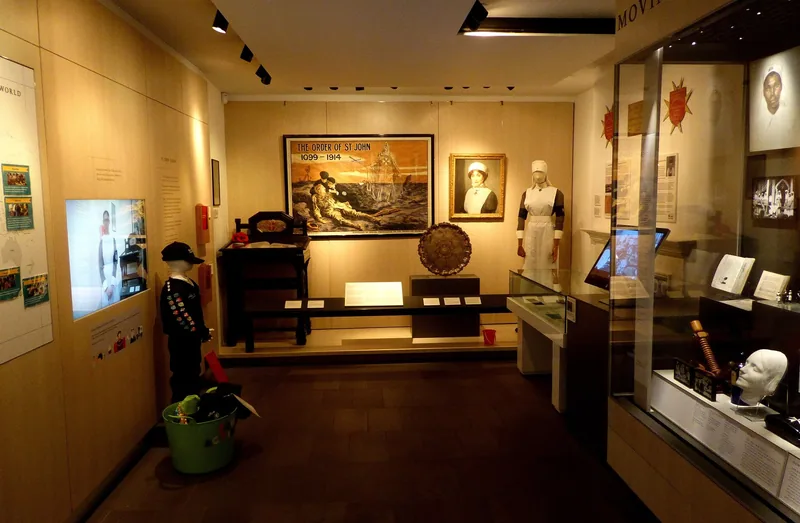 A gallery in the Museum of the Order of St John with display cases, a nurse's uniform and a First World War poster