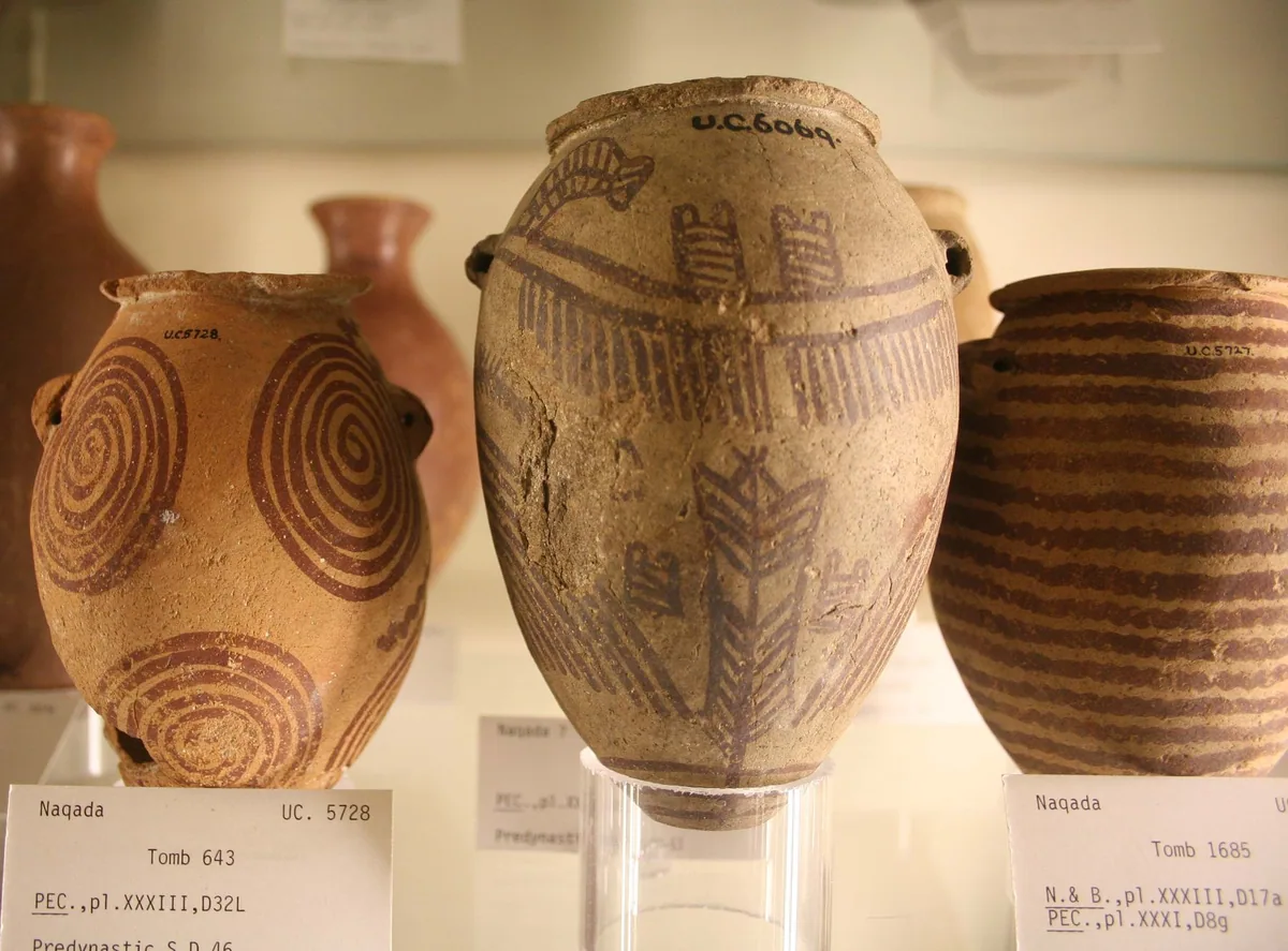 Painted predynastic Egyptian pots with handwritten tomb labels in a display case at the Petrie Museum