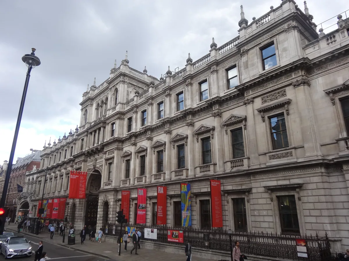 The Piccadilly front of Burlington House hung with red Royal Academy banners
