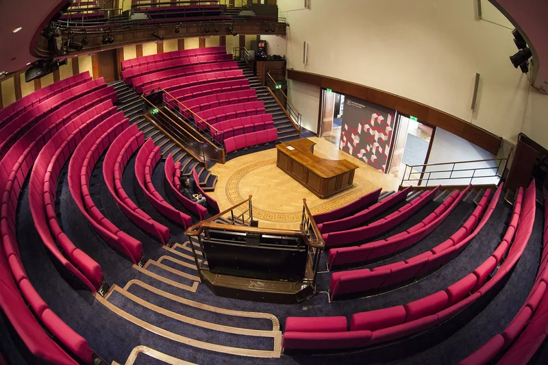 Tiers of red seats curving around the wooden demonstration bench in the Royal Institution's lecture theatre