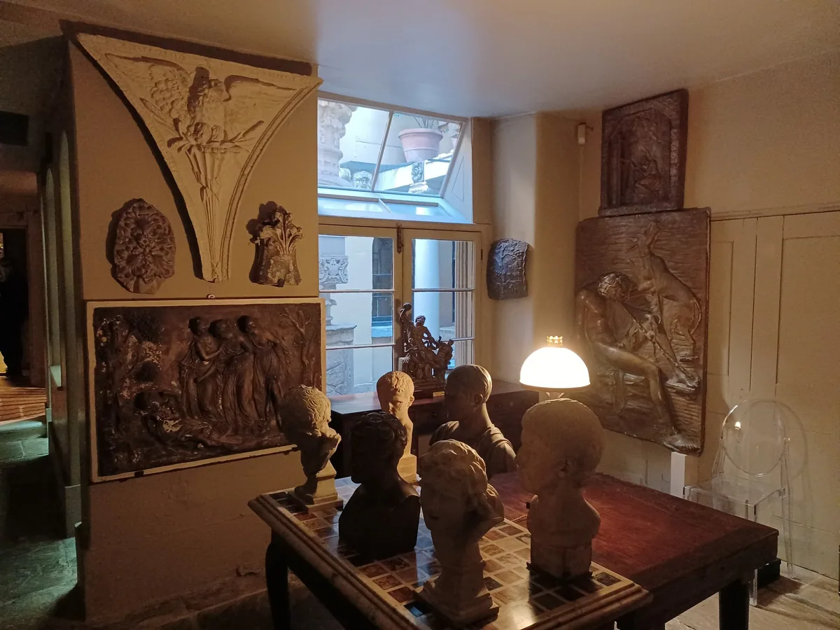 Plaster busts on a table and carved reliefs covering the walls in a room at Sir John Soane's Museum