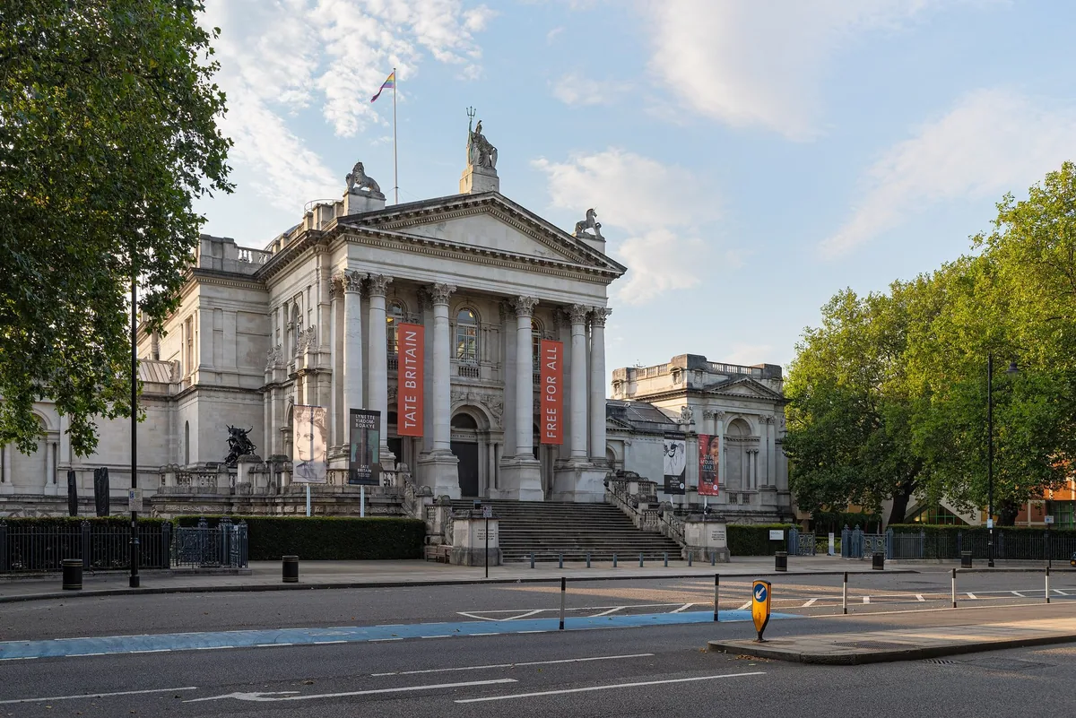 Tate Britain's classical portico and steps on Millbank, seen from the Thames path in evening light
