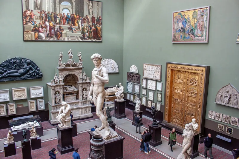 Visitors among plaster casts of classical and Renaissance sculpture in a V&A gallery, with a copy of David at the centre