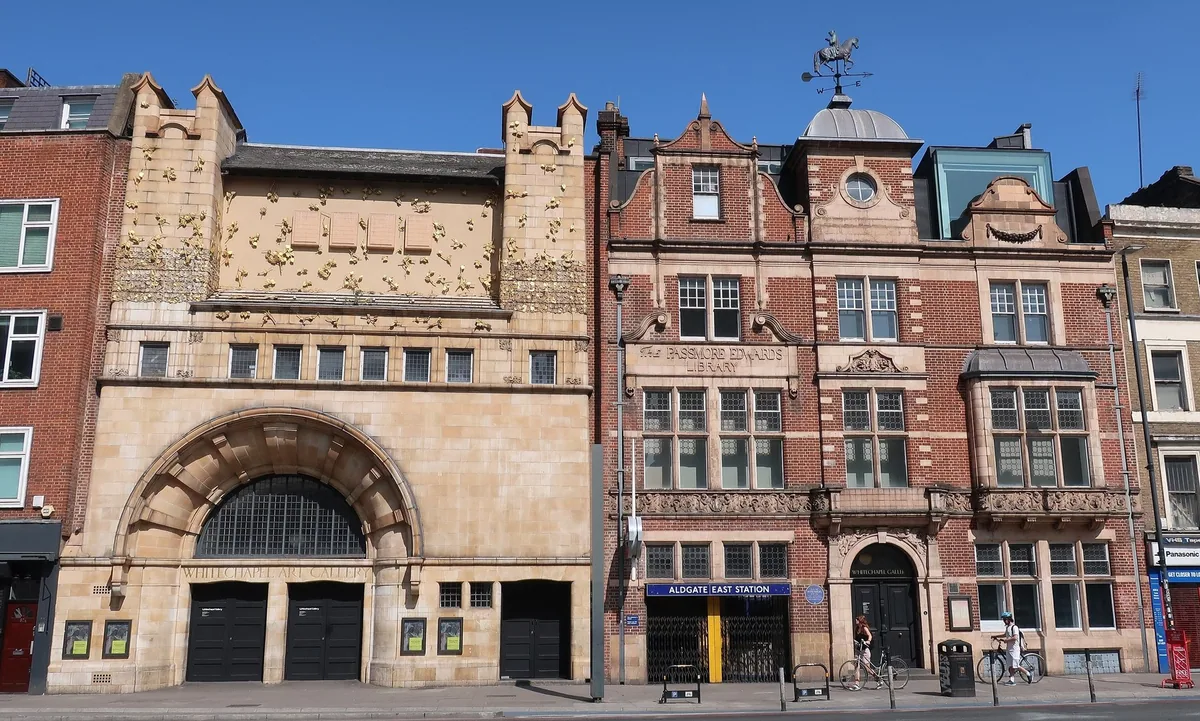 The pale stone Art Nouveau front of Whitechapel Gallery beside the old red brick library on Whitechapel High Street