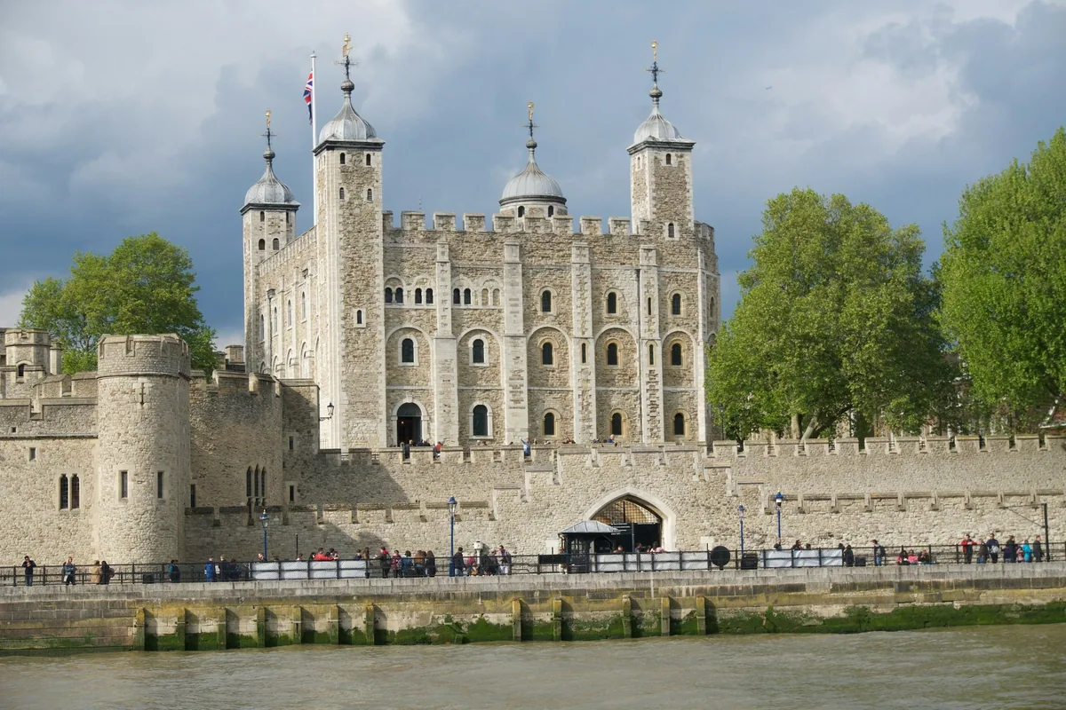 The Tower of London with the White Tower behind its riverside walls, seen across the Thames