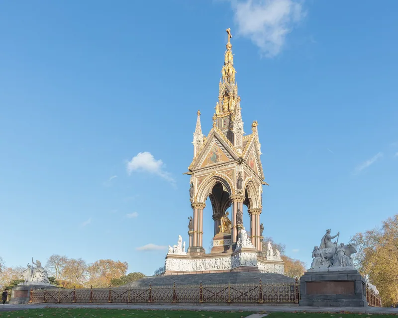 The Albert Memorial seen from one corner in autumn, with marble sculpture groups on its outer plinths