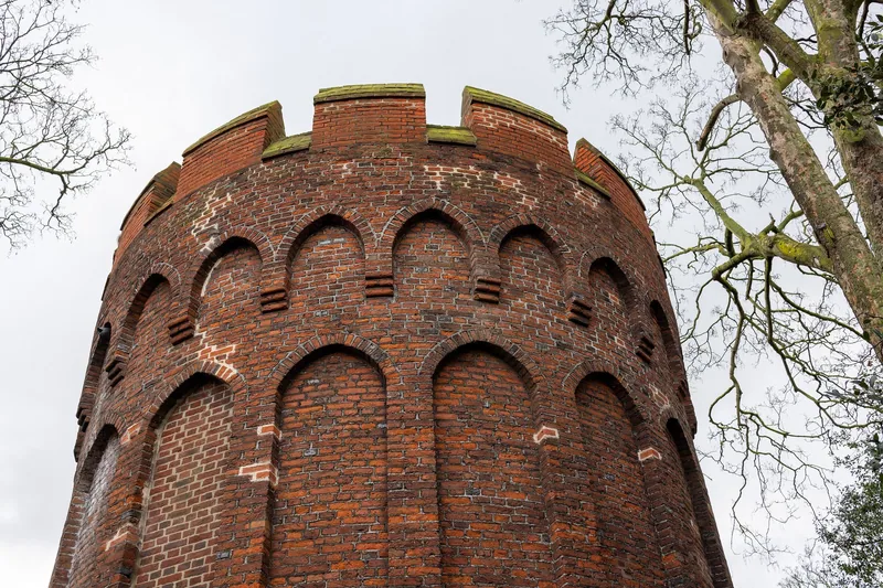 The round brick tower of 1514 beside Bruce Castle, seen from below against bare winter branches