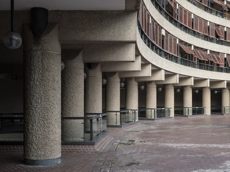 A curving colonnade of hammered concrete columns under the Barbican's Frobisher Crescent