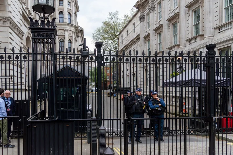 The black security gates closing off Downing Street from Whitehall, with police on duty behind