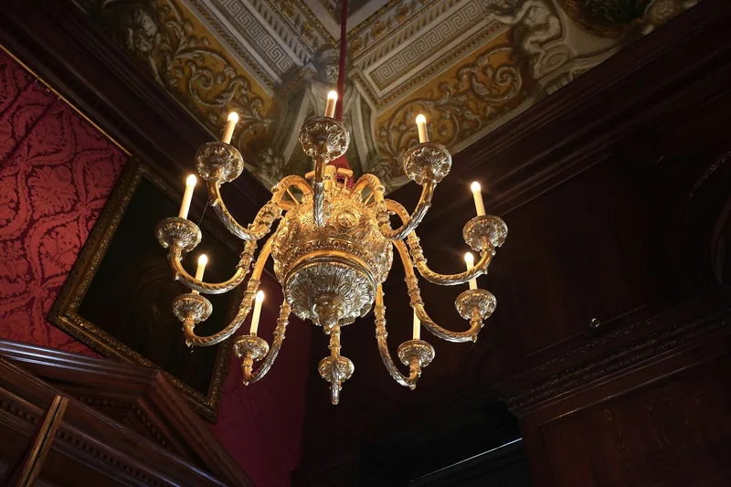 A gilded chandelier hanging in a richly decorated state room inside Kensington Palace