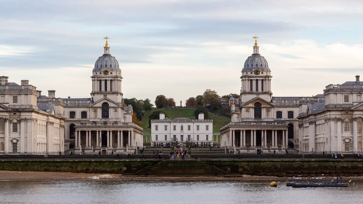The twin domes of the Old Royal Naval College at Greenwich seen from the Thames, with the Queen's House framed between them
