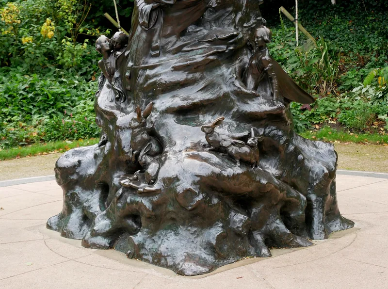The bronze base of the Peter Pan statue, modelled as tree roots with small figures, rabbits and mice climbing over it