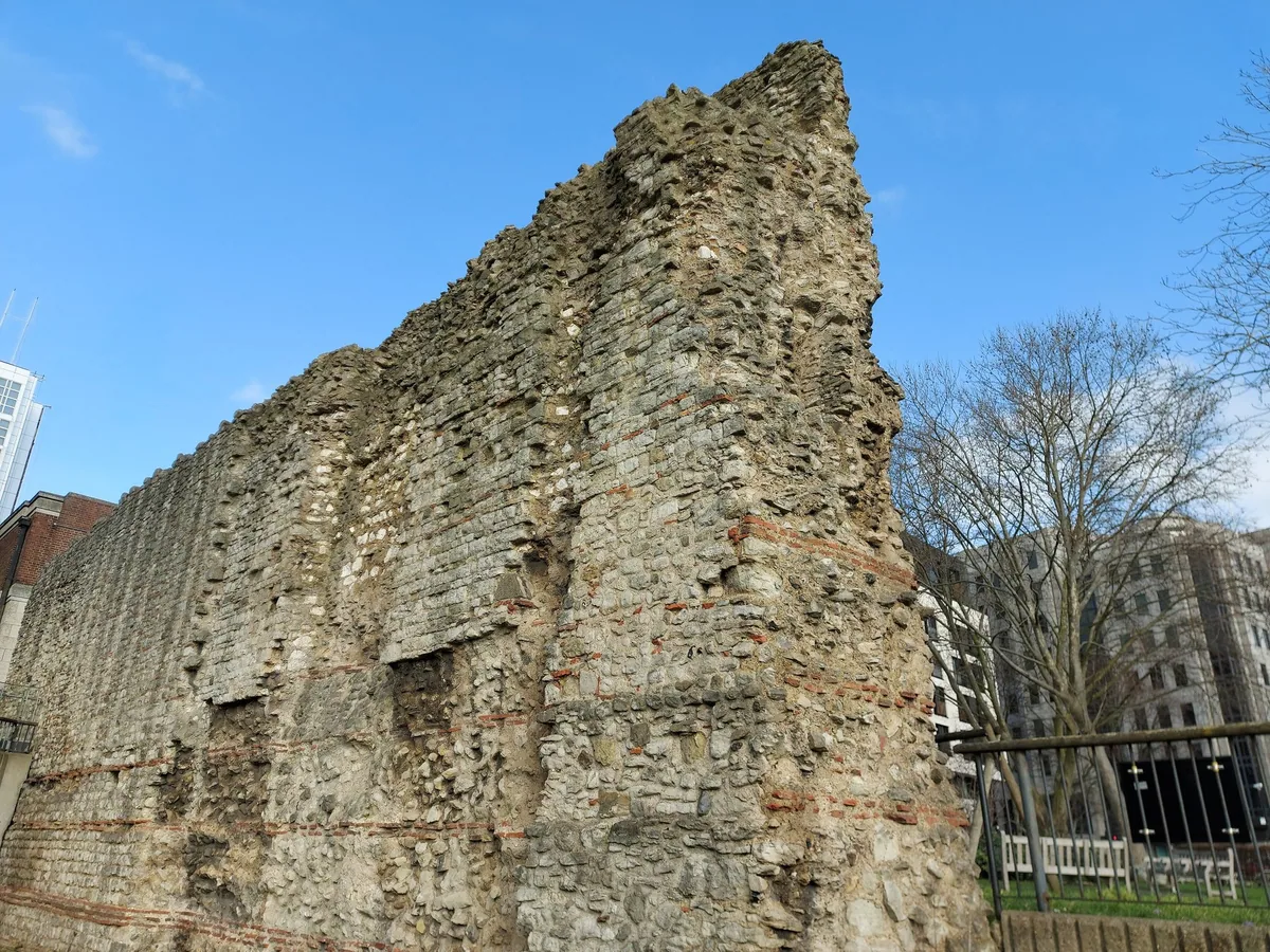A surviving stretch of the Roman city wall at Tower Hill, seen end-on against a bright winter sky