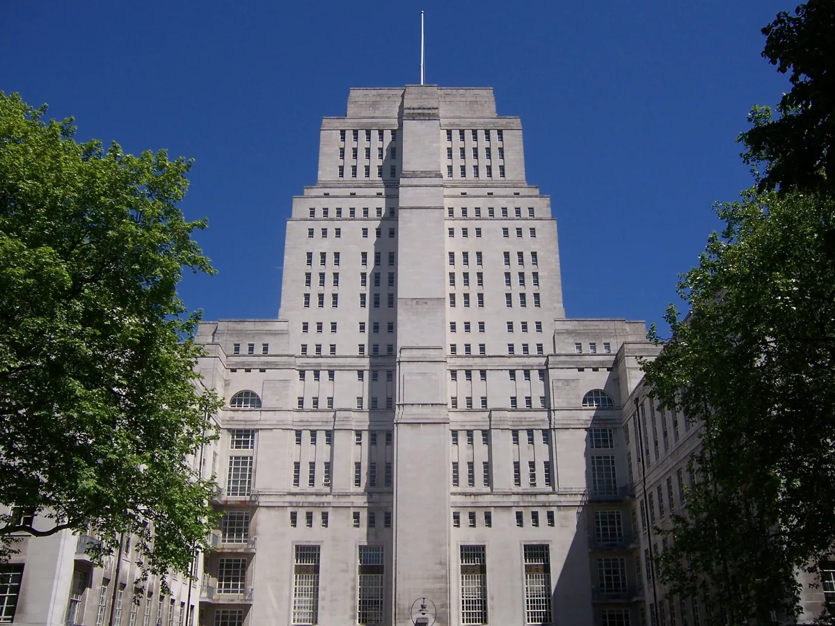 The stepped Portland stone tower of Senate House in Bloomsbury rising above trees against a deep blue sky