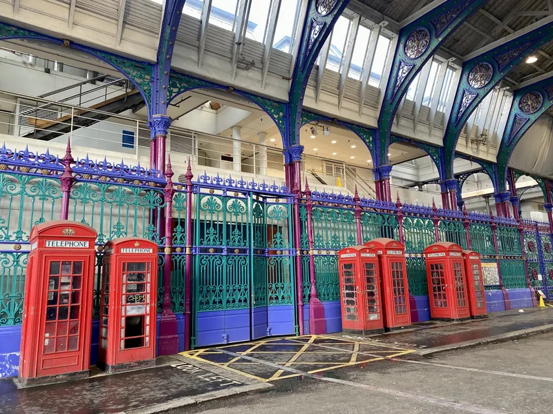 Red telephone boxes beside the painted purple and green ironwork of Smithfield's Grand Avenue