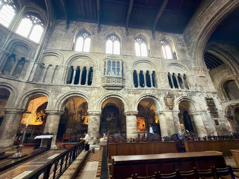 The Norman nave arcade of St Bartholomew the Great, with a carved oriel window set above the arches