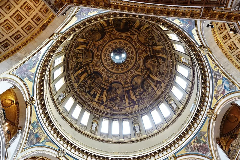 Looking up into the painted inner dome of St Paul's Cathedral, ringed by windows and gilded mosaics