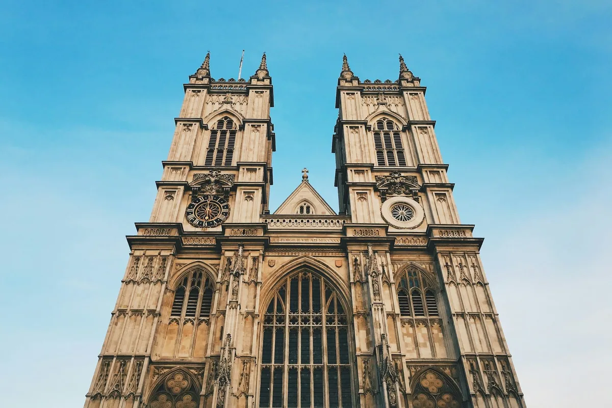 The twin western towers and great west window of Westminster Abbey under a clear blue sky