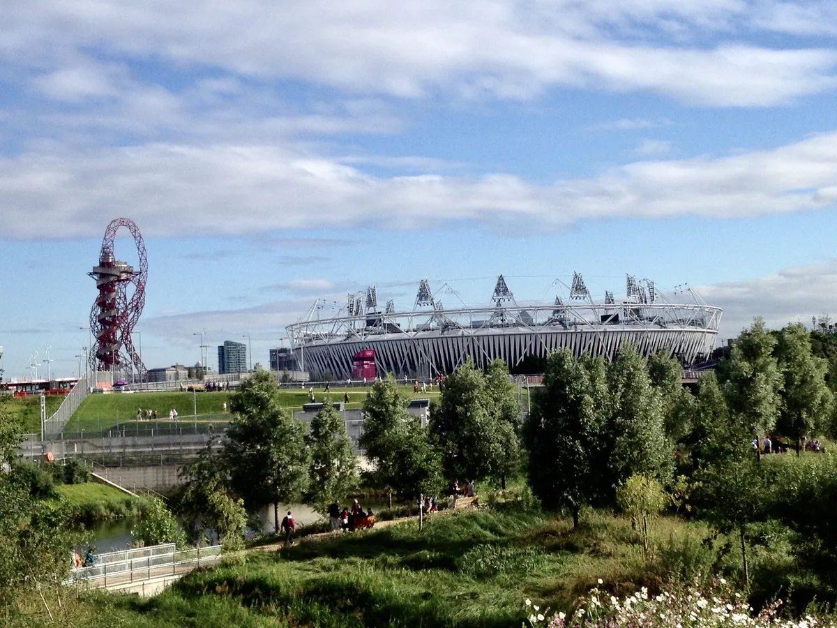 The ArcelorMittal Orbit tower and the London Stadium rising above the green parkland of Queen Elizabeth Olympic Park