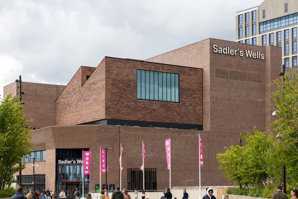 The stepped brick bulk of Sadler's Wells East theatre in Stratford, banners by its entrance