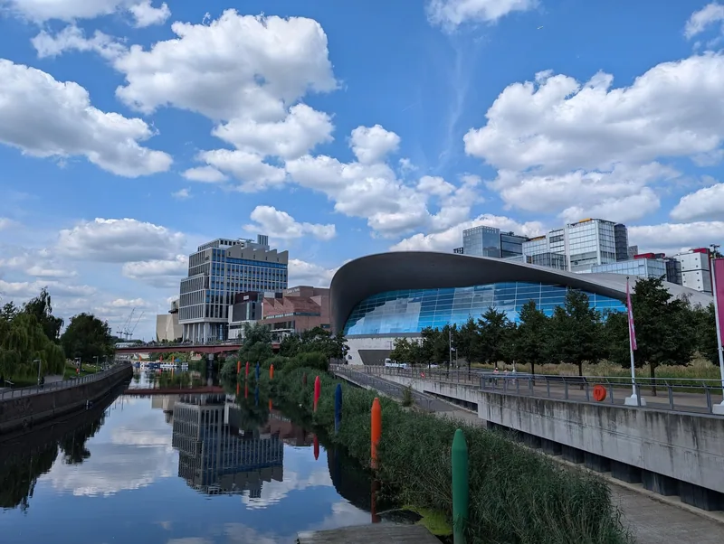 Aquatics Centre and the new East Bank buildings reflected in the canal in the Olympic Park