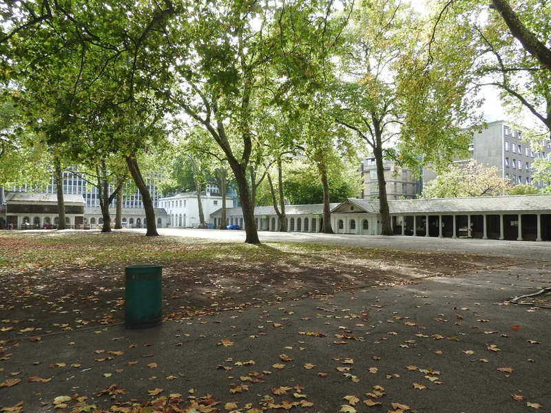 The long arcaded colonnade at Coram's Fields seen across the leaf-strewn yard