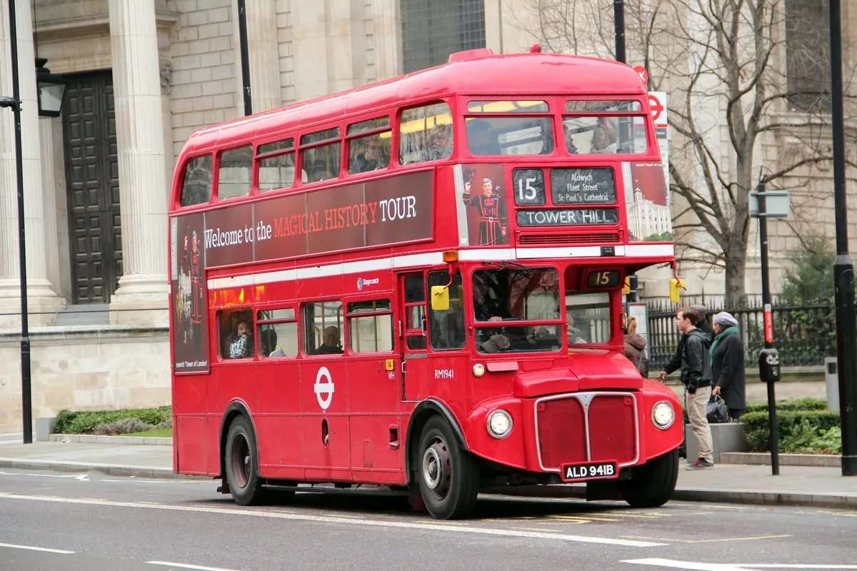 A vintage red Routemaster double-decker on a London tour route, its destination blind reading Tower Hill