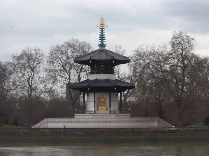 The white and dark-roofed Peace Pagoda in Battersea Park seen from the river, framed by bare winter trees