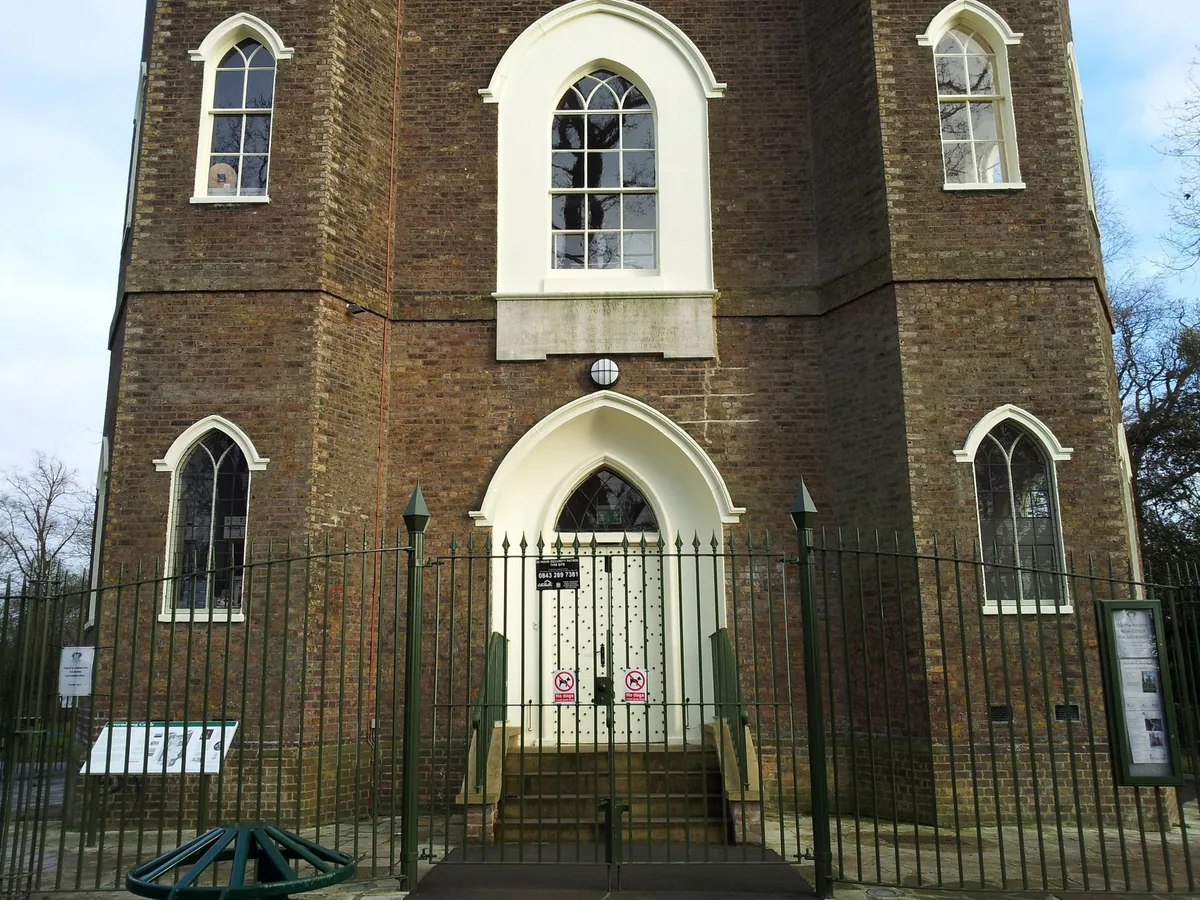 The brick front of Severndroog Castle on Shooter's Hill, with pointed Gothic windows and a white arched doorway behind railings