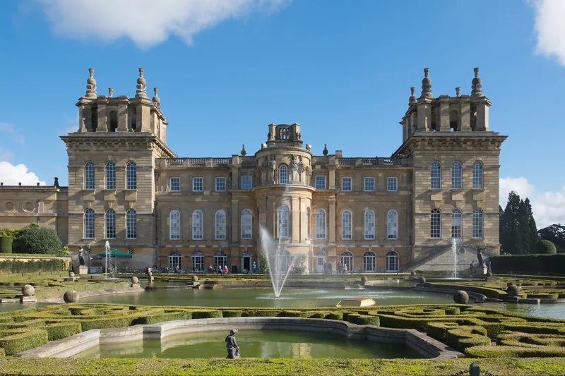 Fountains playing in the formal pool of Blenheim Palace's Water Terraces, with the palace rising behind the clipped parterre