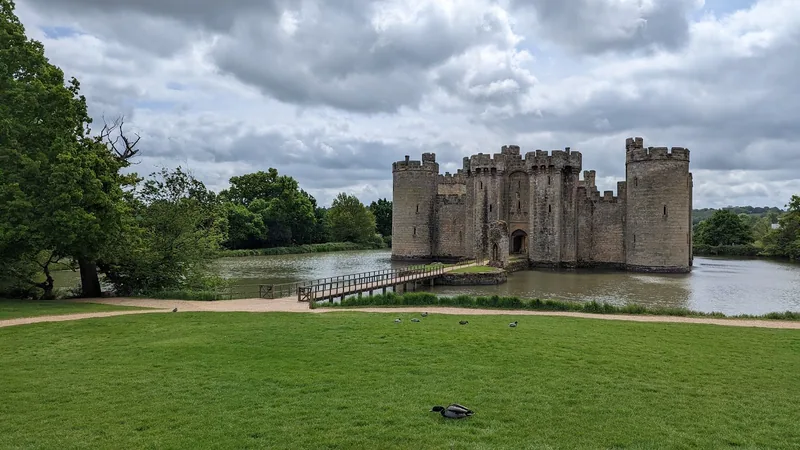 Bodiam Castle from the meadow on the far side of the moat, with the timber footbridge leading across to the gatehouse