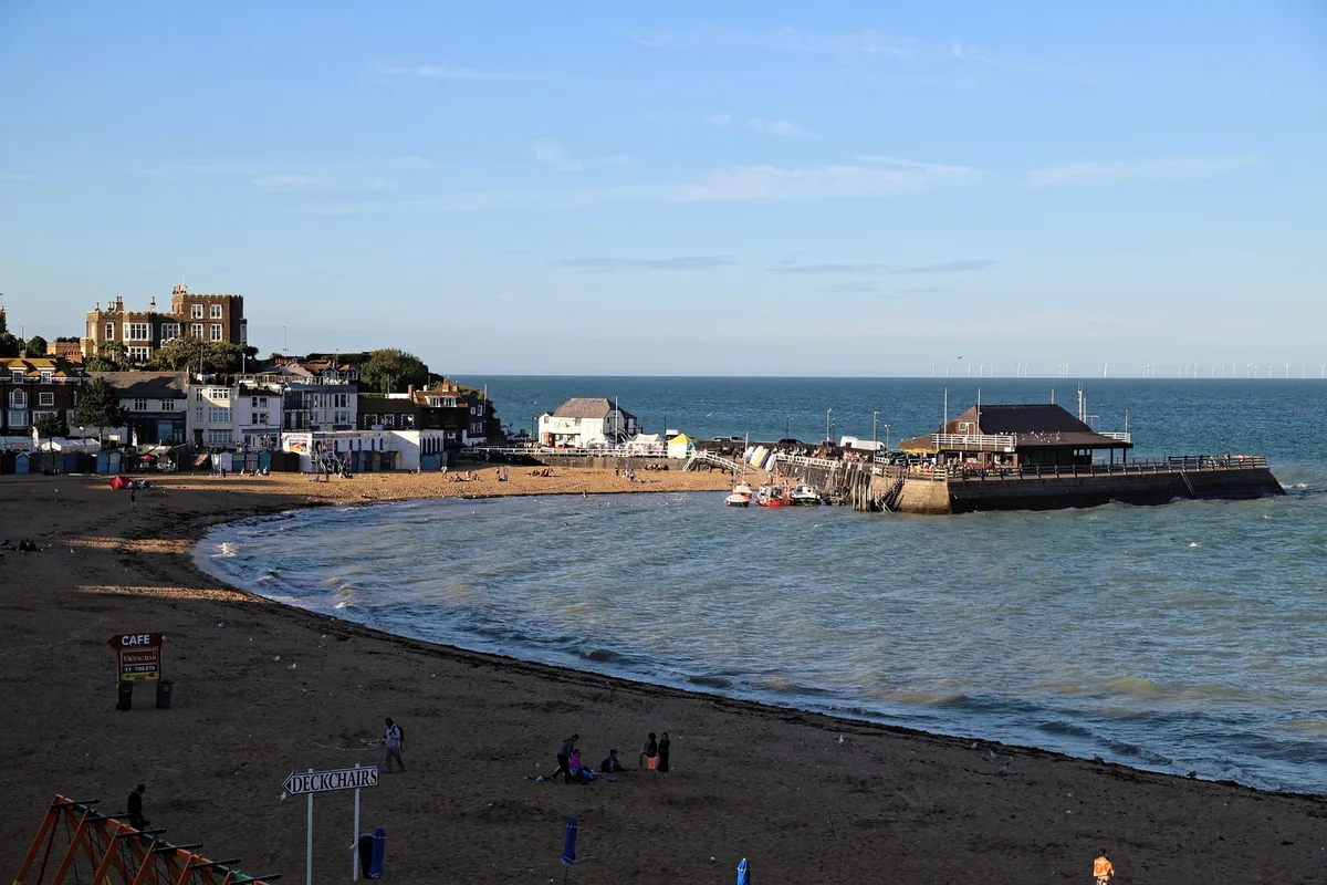 The curve of sand at Viking Bay in Broadstairs, with the stone jetty on the right and the old town stepped up the cliff behind