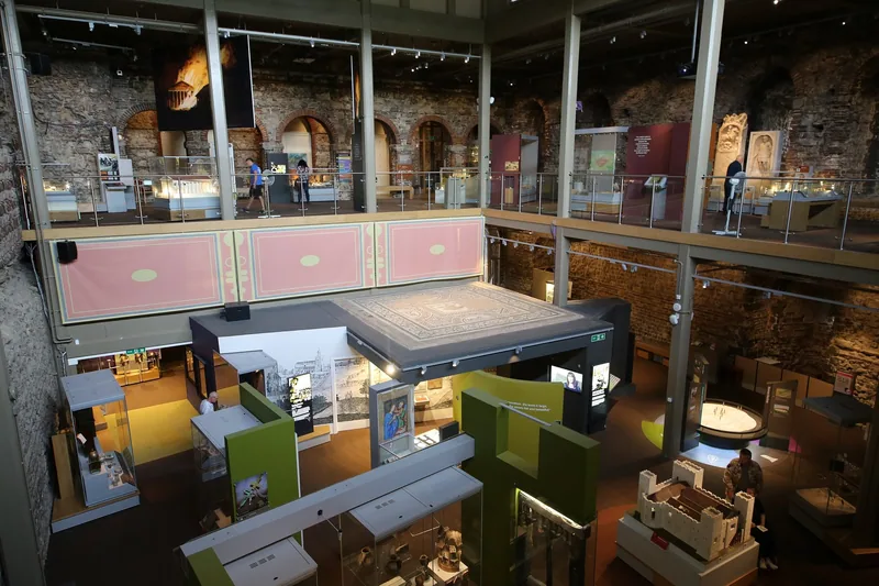 Inside Colchester Castle, where museum galleries on two levels are built into the Norman walls around a Roman mosaic