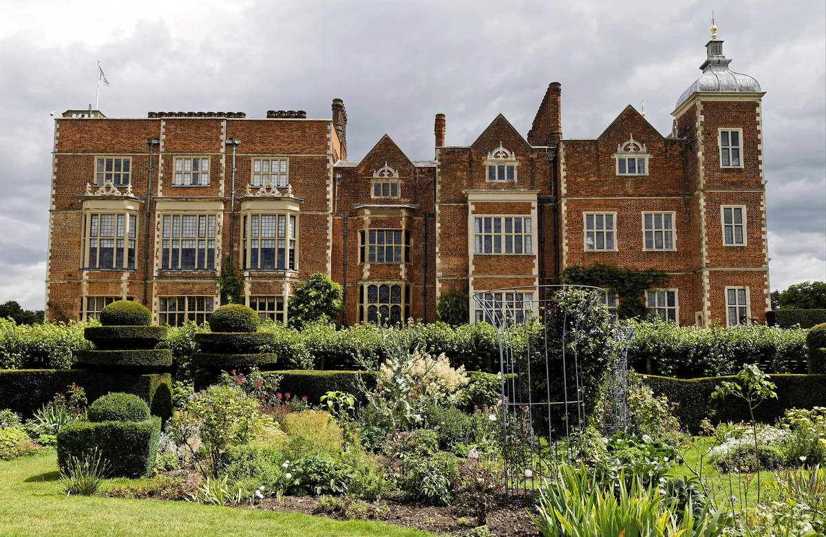 The Jacobean brick west front of Hatfield House rising above its clipped formal garden