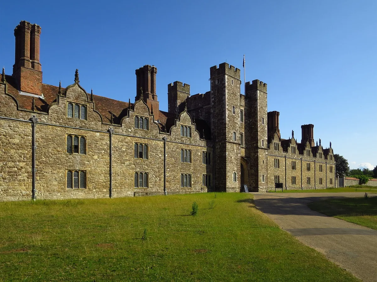 The long stone west front of Knole near Sevenoaks, with its gatehouse tower and brick chimneys