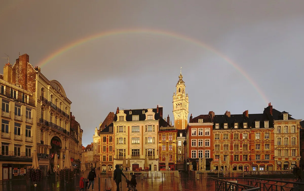 A rainbow over Lille's Grand Place, with the Chamber of Commerce belfry above the Flemish facades