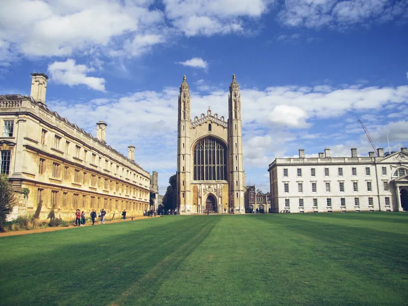 King's College Chapel in Cambridge seen across the college's front lawn under a blue sky