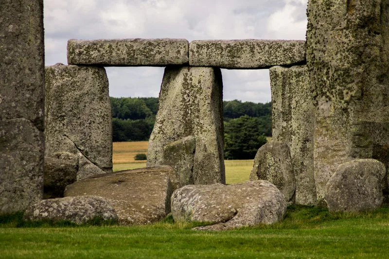 Close view of a Stonehenge trilithon, two upright stones carrying a lintel above the grass